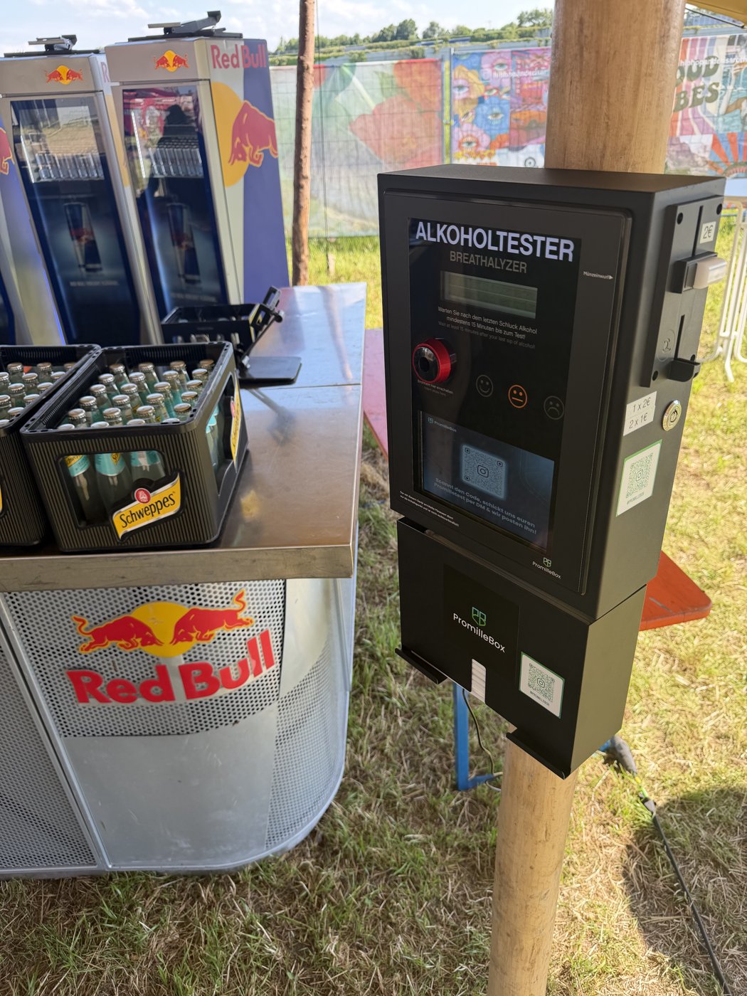 PromilleBox am Getränkestand eines Open-Air-Festivals, montiert an einem Holzpfosten neben Red-Bull-Kühlern